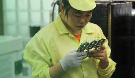 female-chinese-factory-worker-inspecting-a-pcba