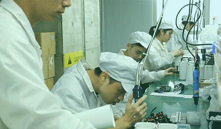 Workers assembling a product wearing white uniform